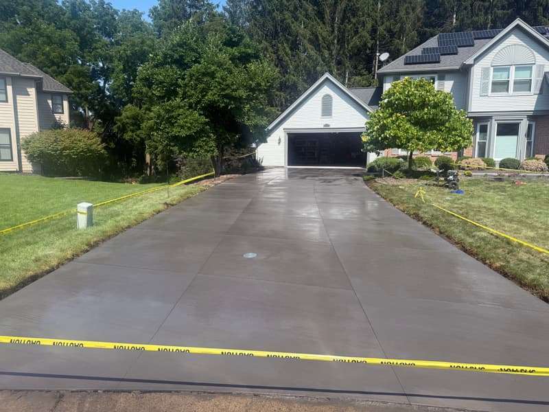 Freshly poured concrete driveway leading to a garage