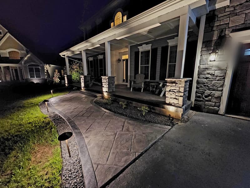 Stamped front walkway lit at night