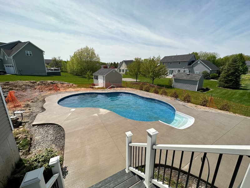 Concrete pool deck around a freeform in-ground pool