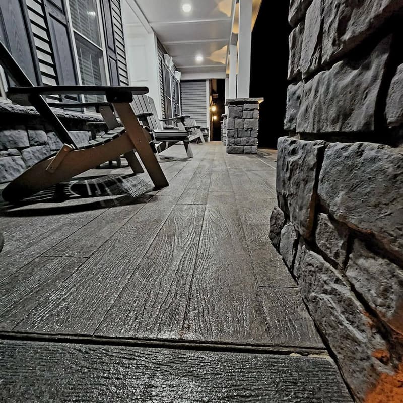 Stacked stone veneer wall beside a wood-plank stamped concrete porch